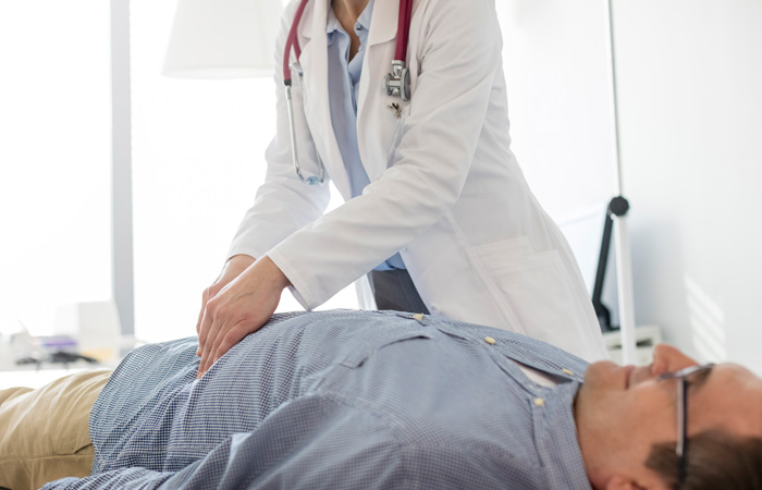 Man on doctor table being checked by doctor