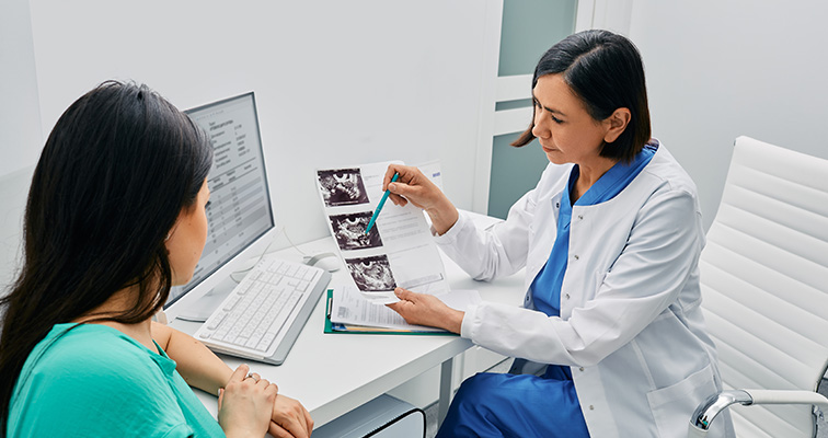 doctor showing female patient ultrasounds